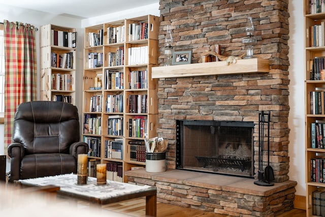 sitting room featuring a stone fireplace and hardwood / wood-style floors