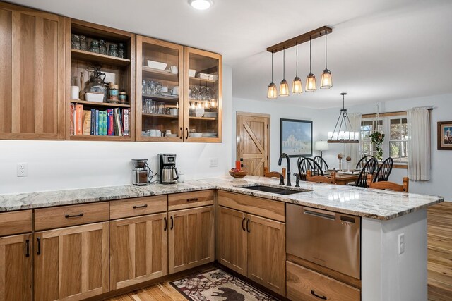 kitchen featuring light wood-type flooring, light stone counters, sink, kitchen peninsula, and stainless steel dishwasher