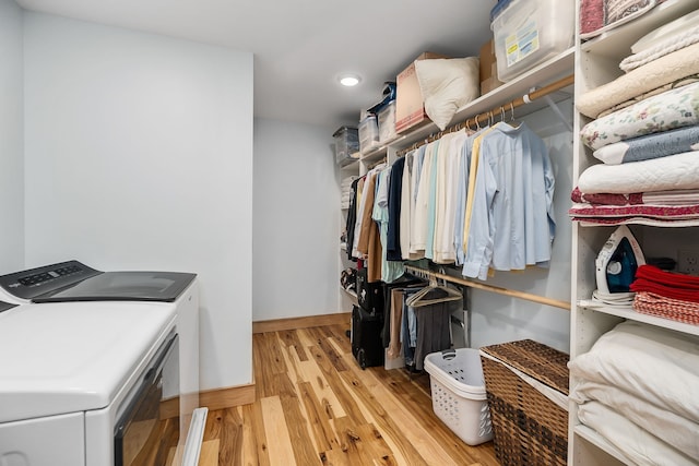 walk in closet featuring light hardwood / wood-style flooring and independent washer and dryer