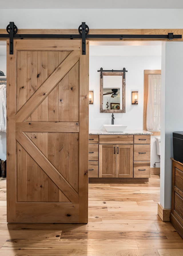 bathroom with toilet, vanity, and hardwood / wood-style floors