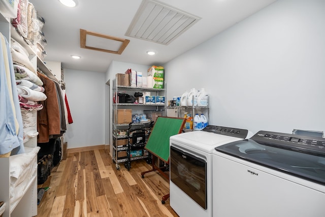 washroom with light wood-type flooring and washer and dryer