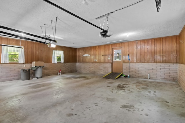garage featuring a garage door opener and wood walls