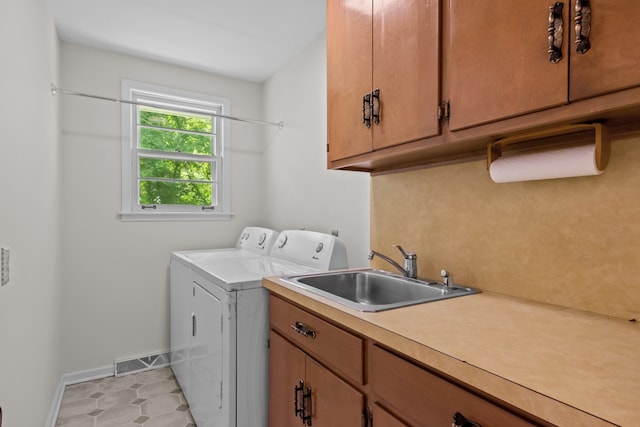 laundry area featuring light tile patterned floors, sink, independent washer and dryer, and cabinets