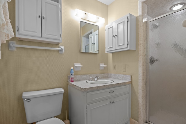 bathroom featuring vanity, toilet, and an enclosed shower