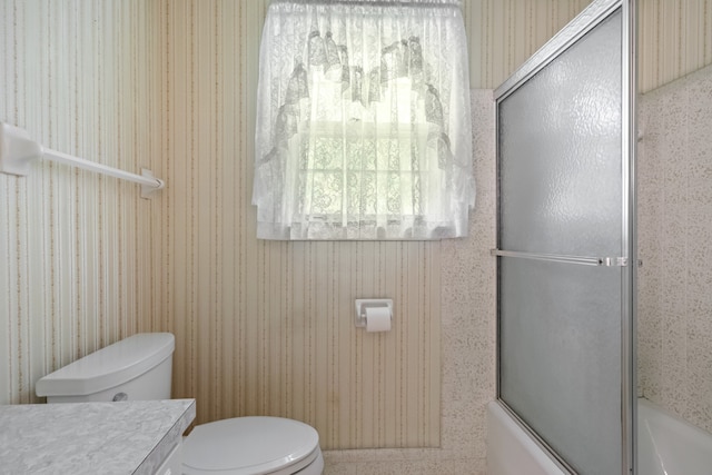 full bathroom featuring shower / bath combination with glass door, vanity, and toilet