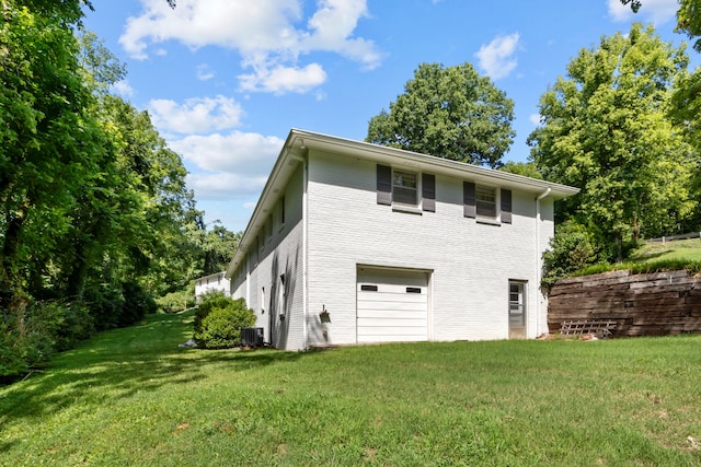 view of property exterior featuring a lawn, central AC unit, and a garage