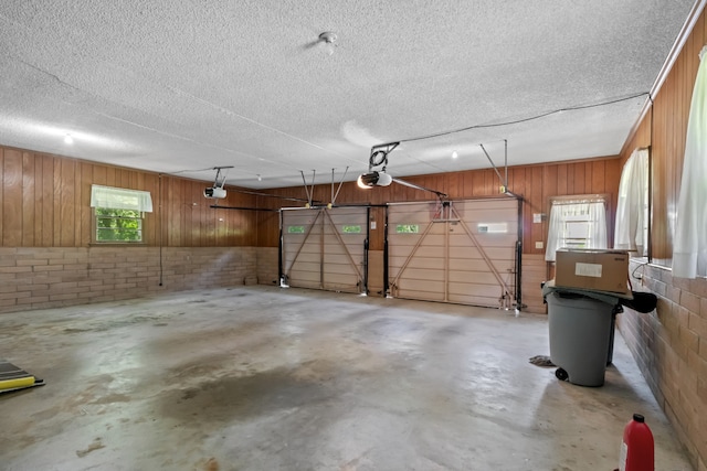 garage featuring a garage door opener and wood walls