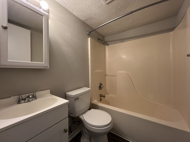 full bathroom with shower / tub combination, a textured ceiling, vanity, and toilet