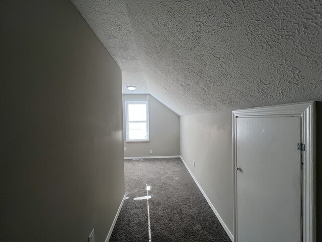 bonus room with a textured ceiling, carpet flooring, and vaulted ceiling