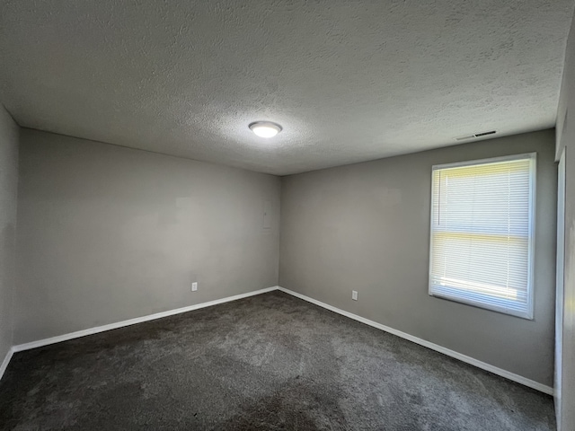 carpeted spare room with a textured ceiling