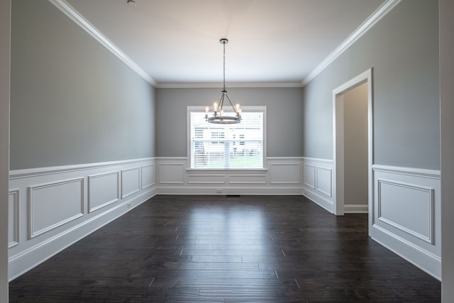 spare room featuring dark hardwood / wood-style flooring, an inviting chandelier, and crown molding