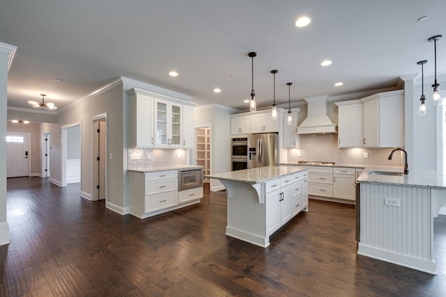 kitchen with appliances with stainless steel finishes, a kitchen breakfast bar, custom exhaust hood, dark hardwood / wood-style floors, and sink