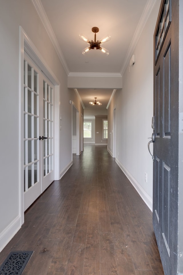 corridor featuring ornamental molding, an inviting chandelier, and dark hardwood / wood-style flooring