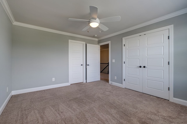 unfurnished bedroom with light carpet, a closet, ceiling fan, and crown molding