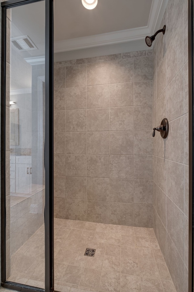 bathroom featuring ornamental molding and tiled shower