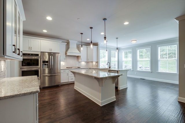 kitchen featuring pendant lighting, premium range hood, appliances with stainless steel finishes, and white cabinetry