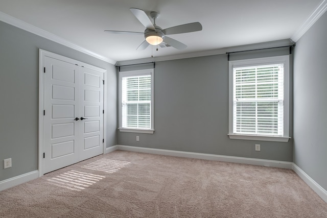 unfurnished bedroom with multiple windows, crown molding, ceiling fan, and light colored carpet