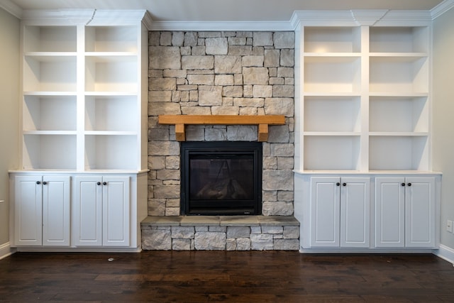 unfurnished living room featuring built in shelves, a fireplace, dark hardwood / wood-style floors, and crown molding