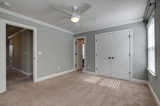 unfurnished bedroom featuring multiple windows, ornamental molding, ceiling fan, and light colored carpet