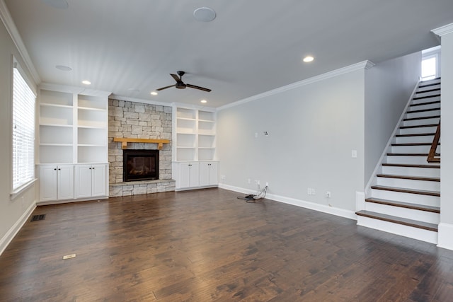 unfurnished living room featuring a fireplace, dark hardwood / wood-style flooring, ceiling fan, built in shelves, and ornamental molding