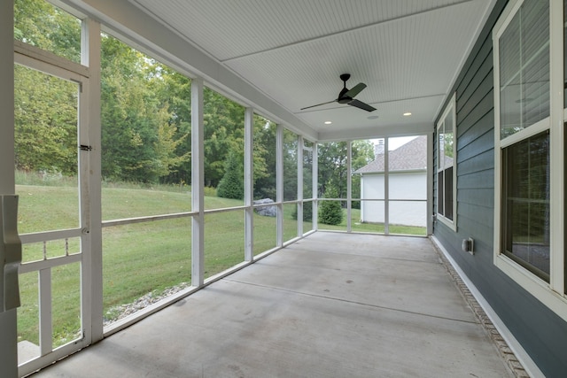 unfurnished sunroom featuring ceiling fan and a wealth of natural light