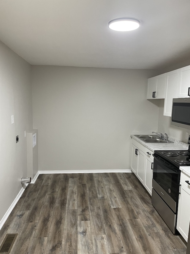 kitchen with dark hardwood / wood-style floors, white cabinetry, sink, and electric range