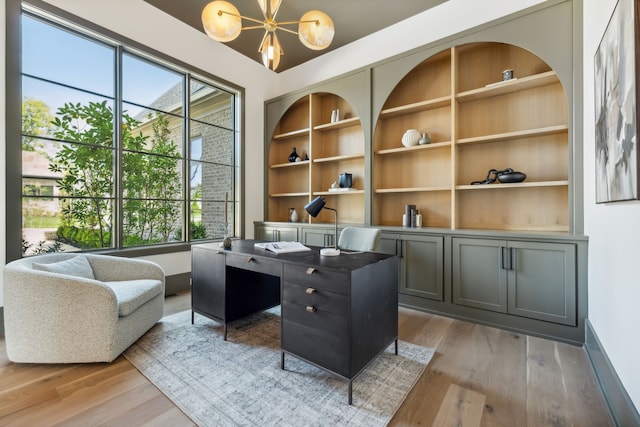 office featuring a chandelier, built in features, and hardwood / wood-style floors