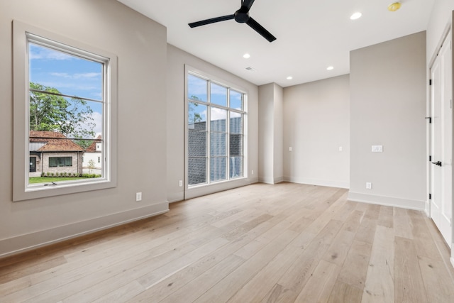 empty room featuring ceiling fan, a healthy amount of sunlight, and light hardwood / wood-style floors