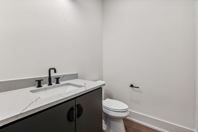 bathroom featuring hardwood / wood-style flooring, vanity, and toilet