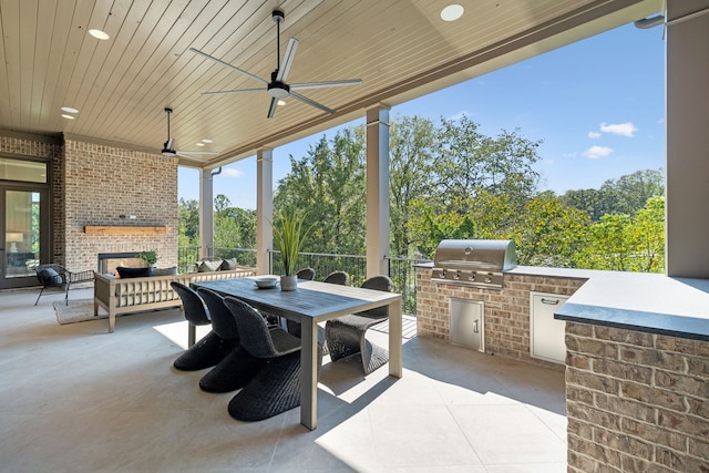 view of patio / terrace with an outdoor brick fireplace, ceiling fan, exterior kitchen, and grilling area