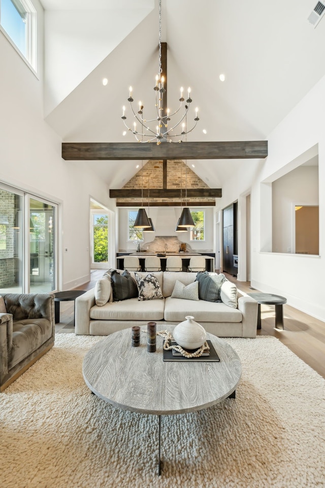 living room with hardwood / wood-style floors, beam ceiling, and a chandelier