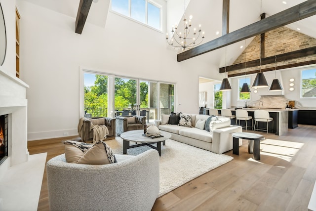 living room with a healthy amount of sunlight, a towering ceiling, and light hardwood / wood-style floors