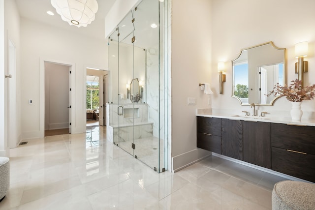 bathroom featuring vanity, an enclosed shower, a towering ceiling, and an inviting chandelier