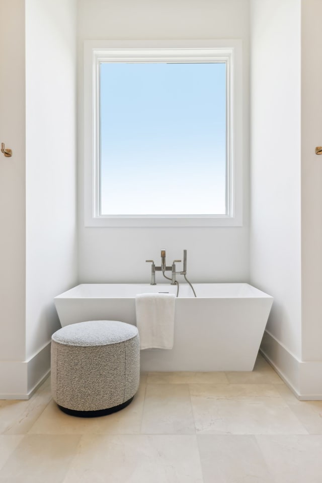 bathroom with a bathtub and tile patterned flooring