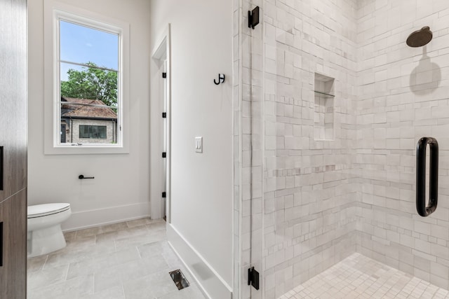 bathroom featuring tile patterned floors, toilet, and a shower with door