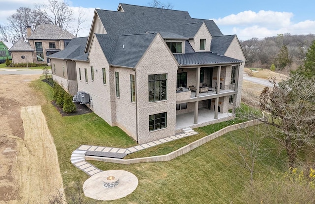 rear view of house featuring a lawn, central air condition unit, and a patio