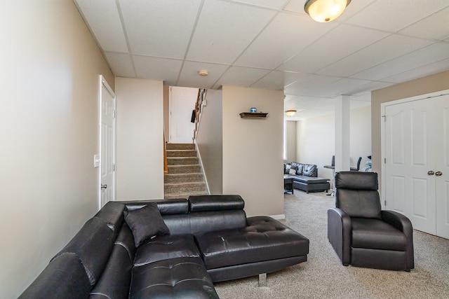 carpeted living room with a drop ceiling