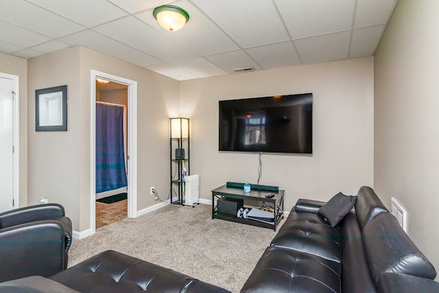 carpeted living room with a drop ceiling