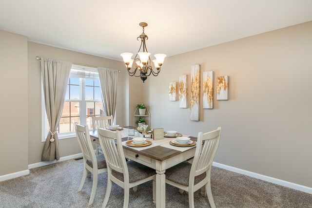 dining room with carpet floors and a chandelier