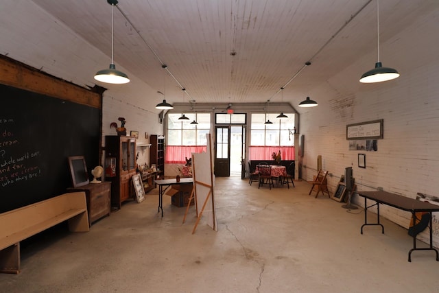 misc room with brick wall and concrete floors