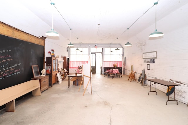 miscellaneous room with brick wall and concrete floors