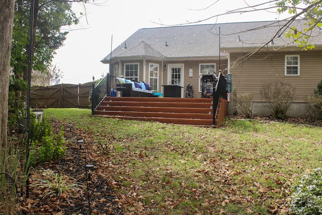 rear view of property with a deck and a yard