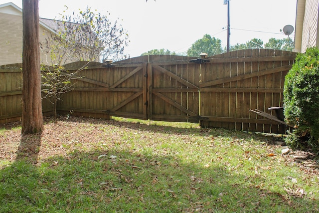 view of gate featuring a yard