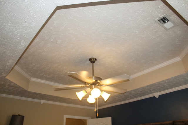 interior details featuring ceiling fan, a textured ceiling, and ornamental molding