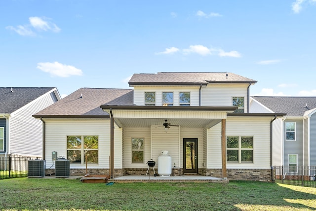 back of property featuring central AC unit, a lawn, and ceiling fan