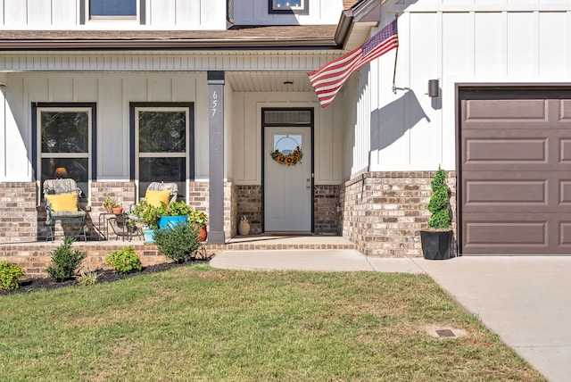 property entrance with a garage, a porch, and a lawn