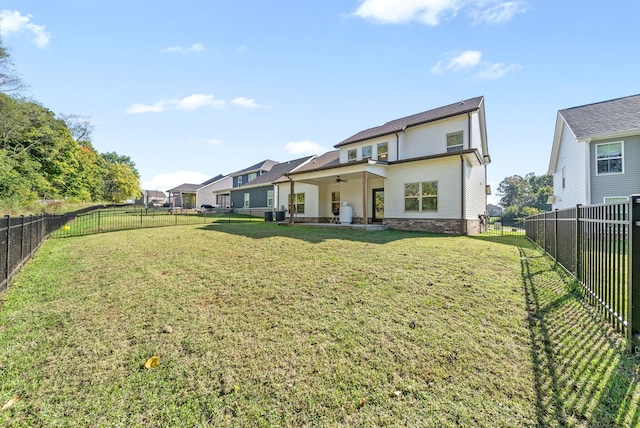 rear view of house with a patio area and a lawn