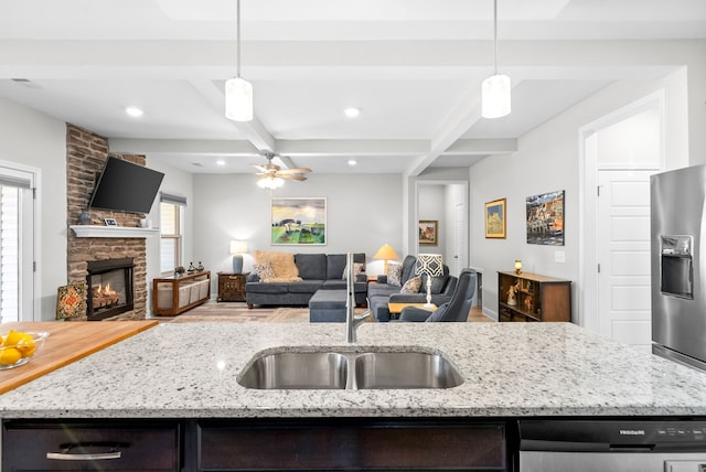 kitchen featuring a fireplace, beam ceiling, and hanging light fixtures