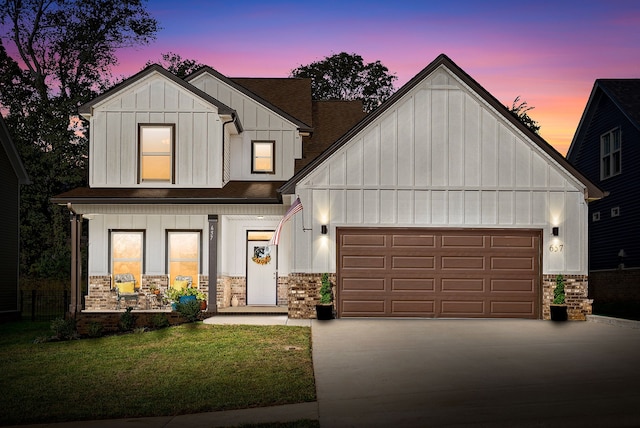 modern farmhouse featuring a garage and a yard