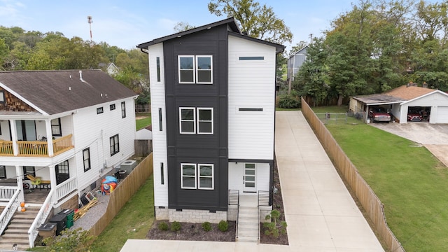 view of front of house featuring a balcony, an outdoor structure, and a front lawn